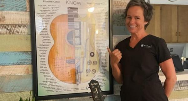Owner Paula Rivers with poster of the ear and music