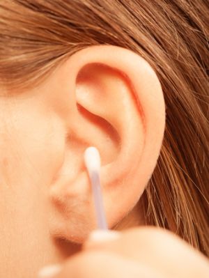 closeup of ear with cotton swab going in