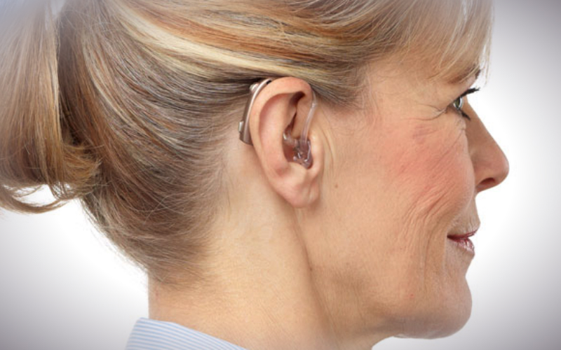 A woman wearing an Oticon Dynamo power hearing aid