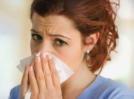 Woman With Tissue Over Mouth and Nose