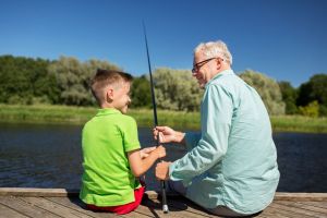 A grandson fishes with this grandfather.