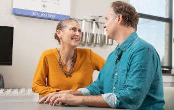 A couple talks at a hearing aid clinic.