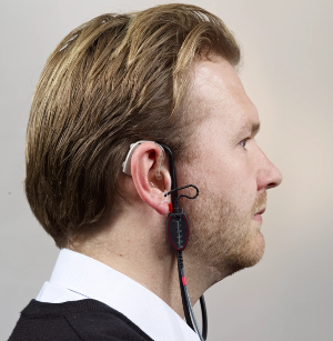 A man with hearing aid and real ear measurement equipment in his ear.