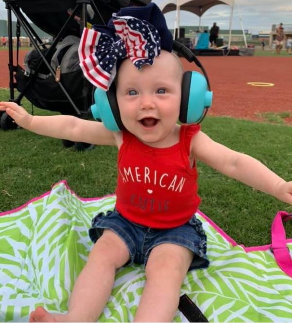 Cute baby girl with ear protection on