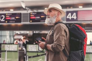 An older man walks through an airport.