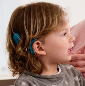 A boy wears a cochlear implant.