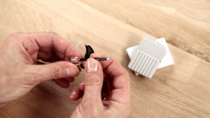 Demonstration of how to change wax guard in a hearing aid.
