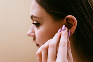 Une femme met des bouchons d'oreilles.