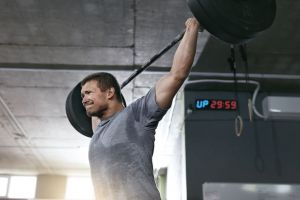 A man strains while doing a power press.