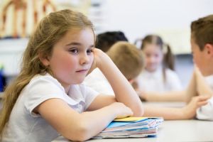 young girl in classroom looking distracted and distant