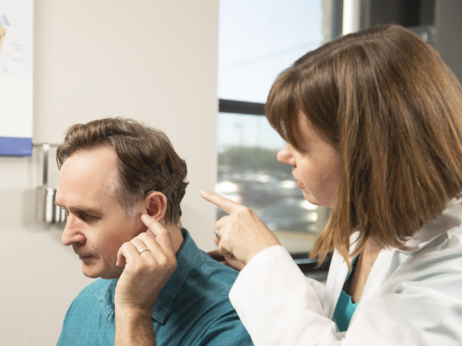 An ENT doctor examines a man's ear. 