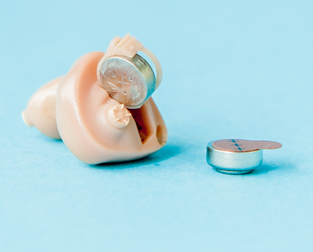 A hearing aid with battery case open.