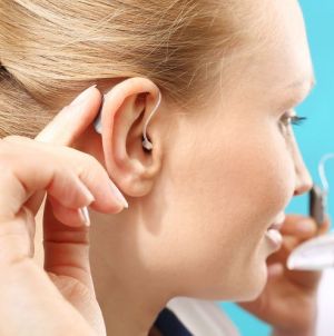 A woman wears a hearing aid.