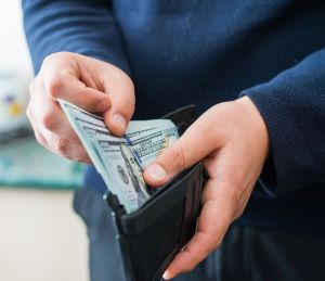 Man's hands holding wallet with money inside