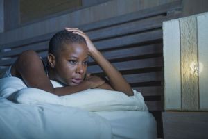A woman in bed with insomnia and tinnitus.
