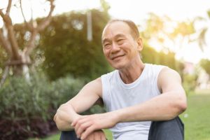 A man smiles in his backyard.