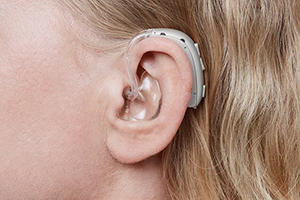 A woman wearing an Oticon Xceed power hearing aid.