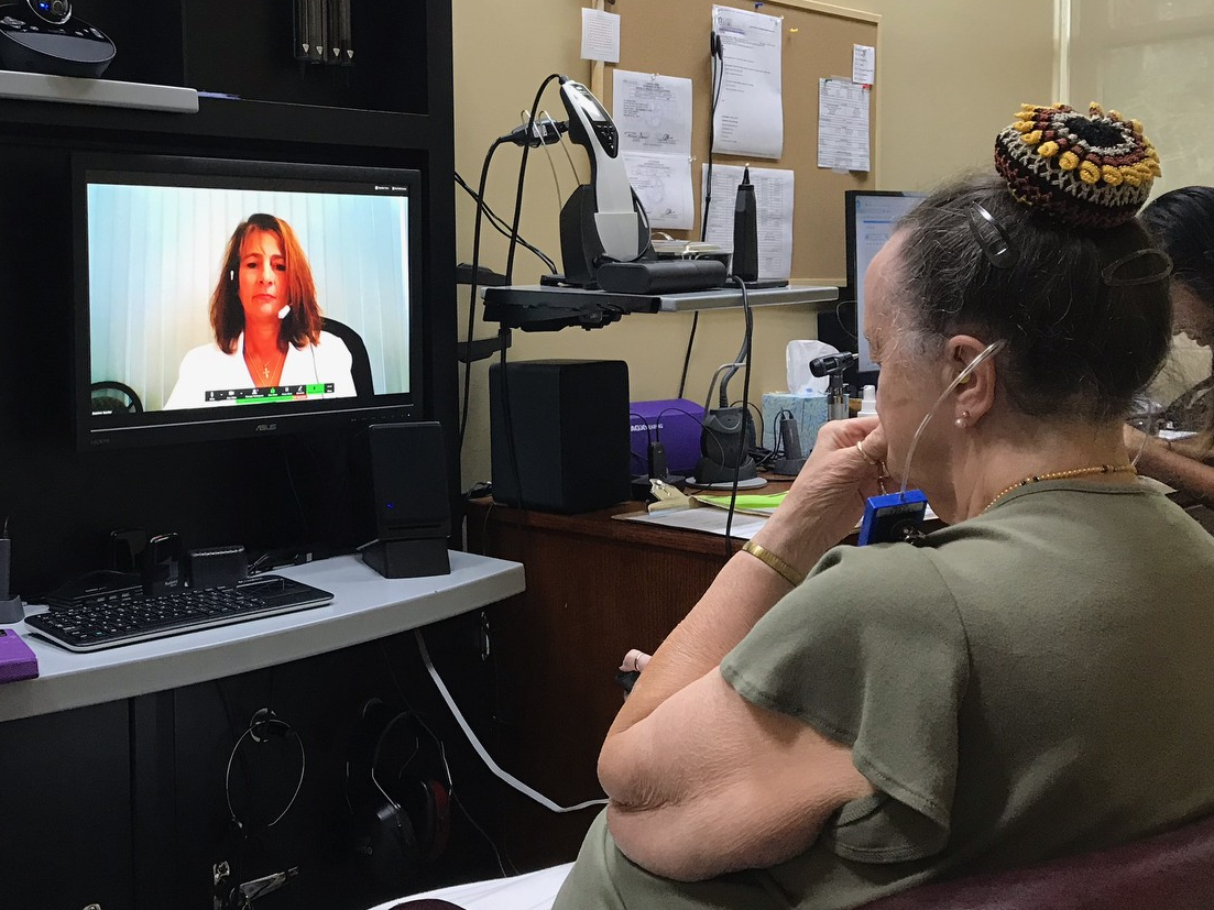 A woman receives a hearing evaluation using teleaudiology. 