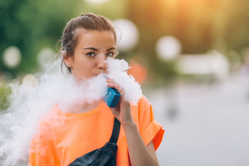 A teenager uses a vaping ecigarette.
