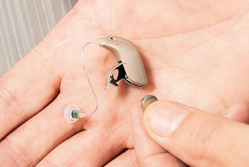 A hearing aid with the battery shown.