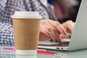 woman working on laptop with coffee cup nearby