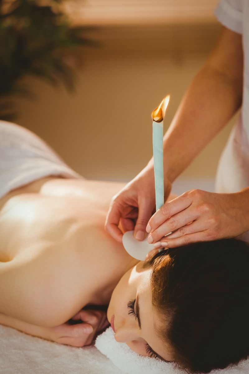 A woman receives ear candling, a dangerous alternative practice. 