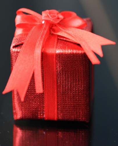 package wrapped in red paper with a red bow