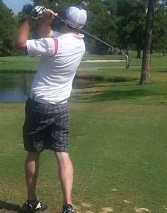 Young man swinging a golf club