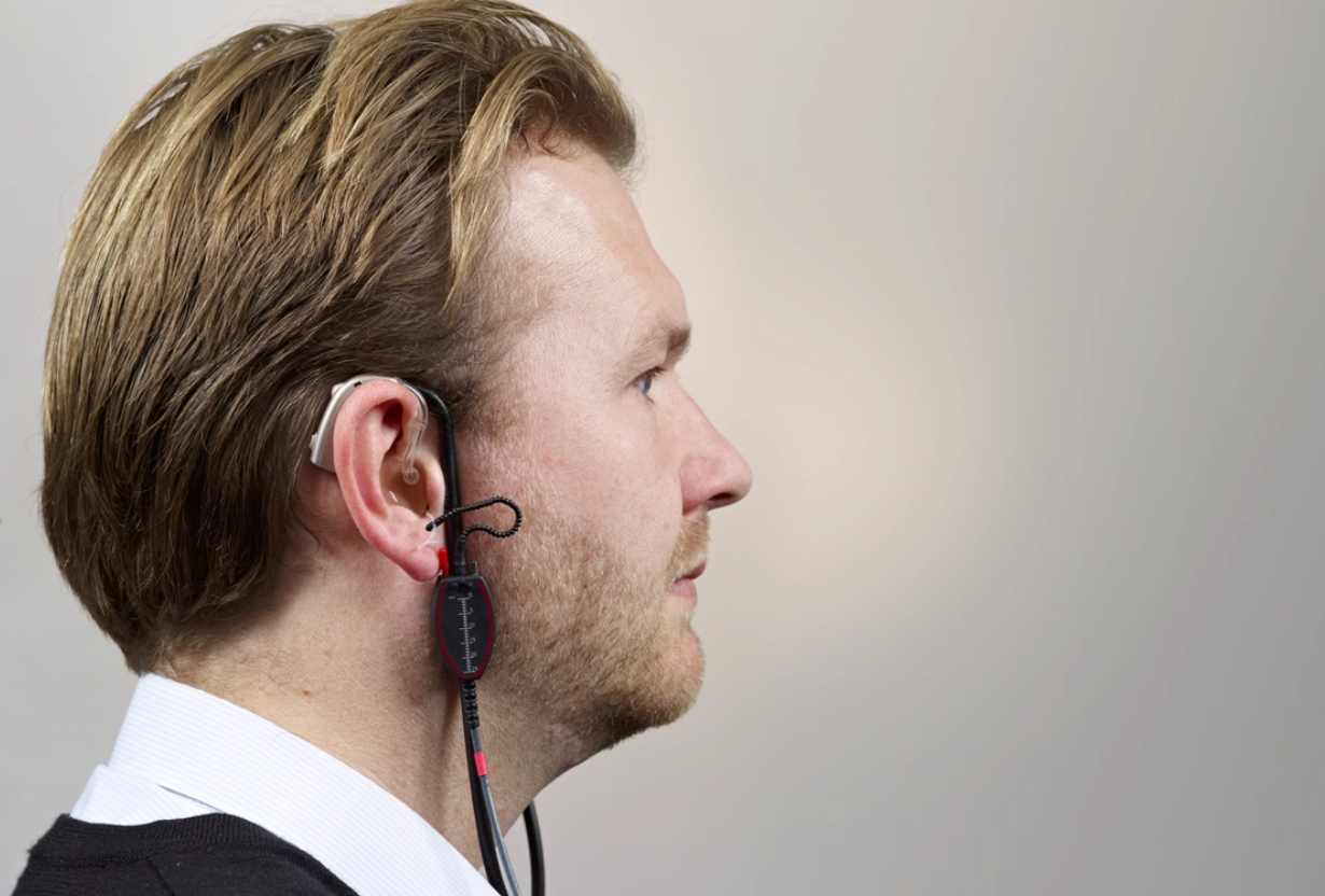 A man with real ear measurement equipment in his ear. 